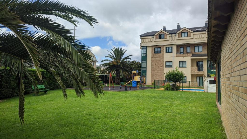 a building with a palm tree next to a park at Refugio de mar in Barreiros
