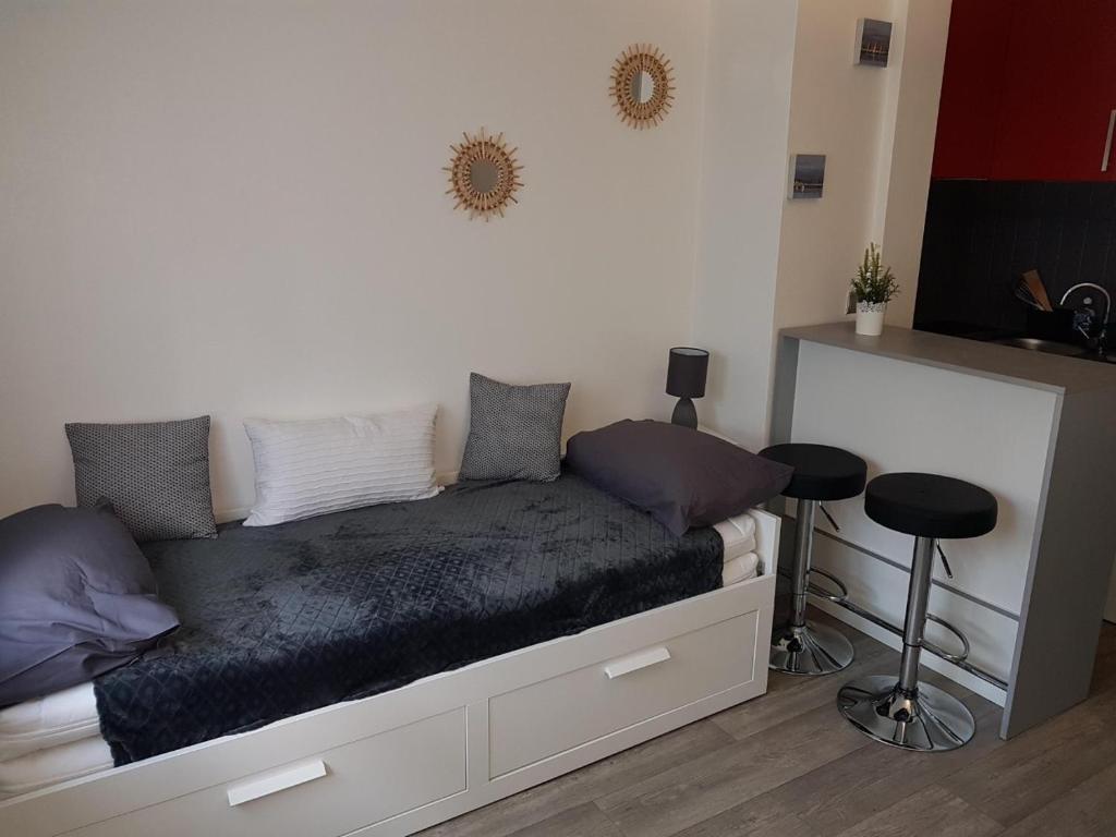 un lit dans une chambre avec une table et un tabouret dans l'établissement Studio, à Bayonne