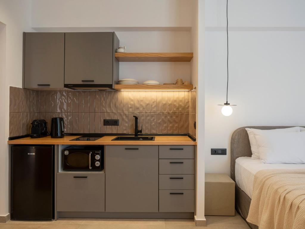 a small kitchen with a sink and a bed at Anemelia way of living in Naousa
