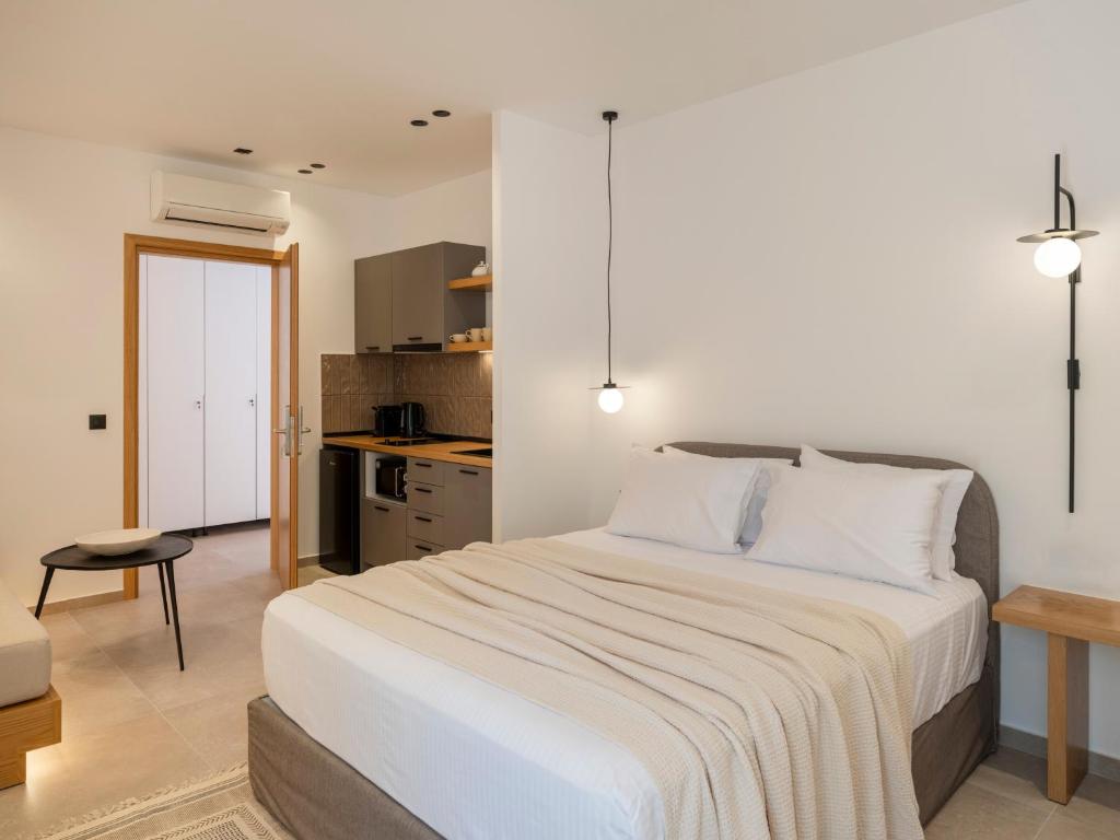 a bedroom with a large bed and a kitchen at Anemelia way of living in Naousa