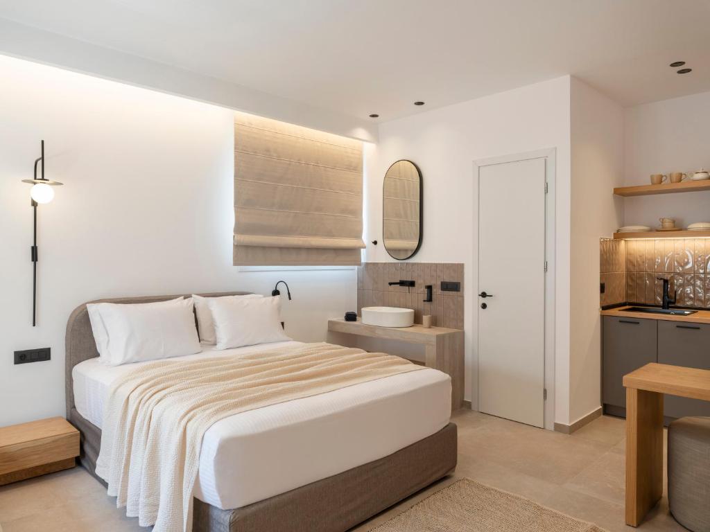 a bedroom with a large bed and a kitchen at Anemelia way of living in Naousa