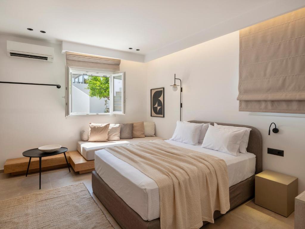 a bedroom with a large bed and a couch at Anemelia way of living in Naousa