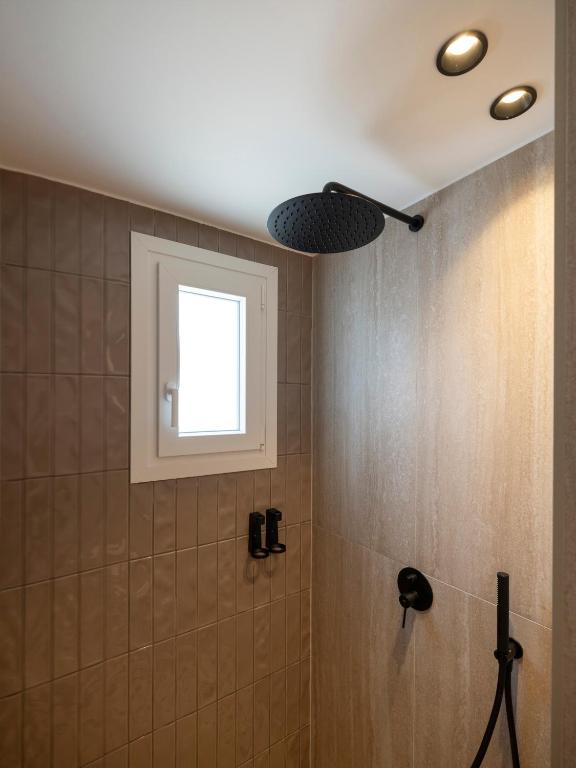 a bathroom with a shower with a window at Anemelia way of living in Naousa