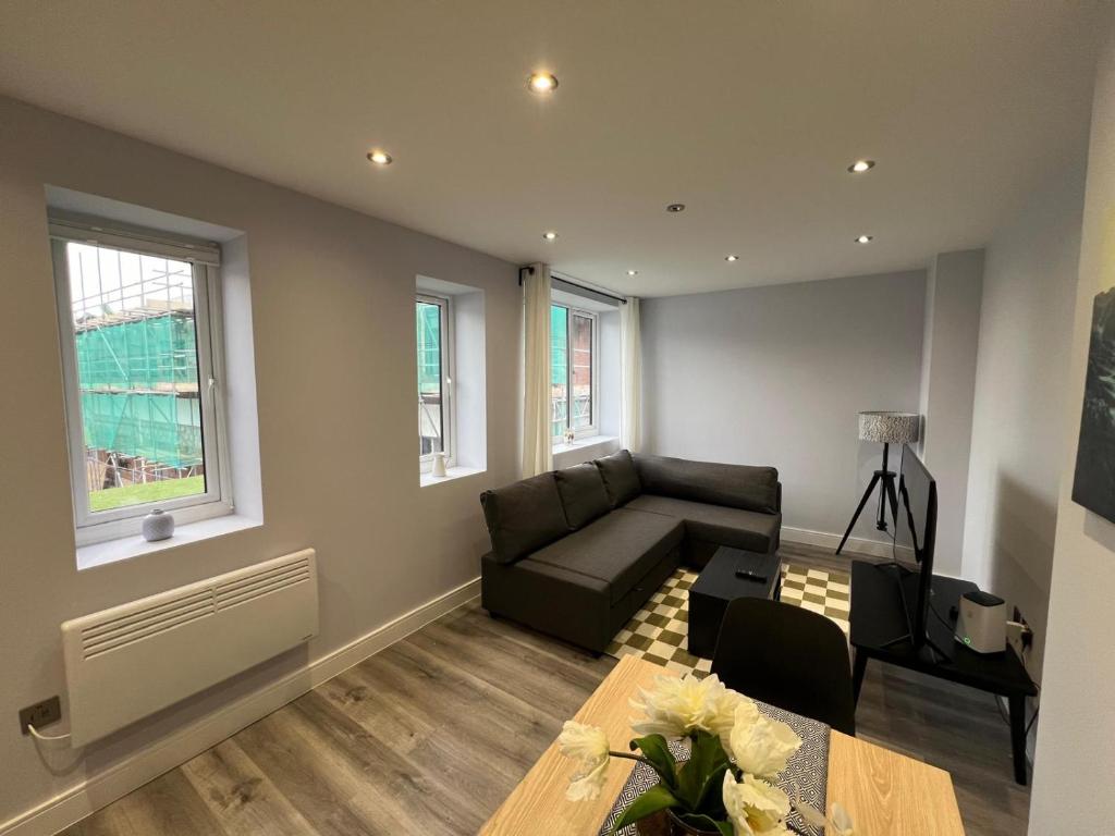a living room with a couch and a table at Queen Apartment - High Spec - En-Suites - 7 Guests in Abingdon