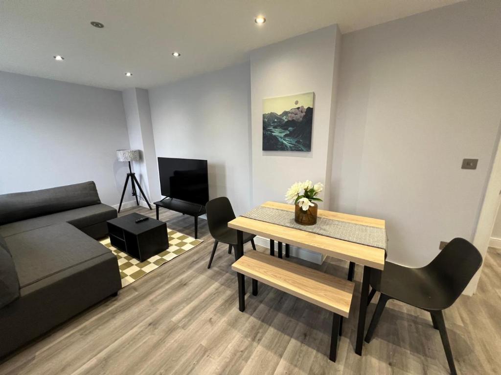 a living room with a couch and a table at Queen Apartment - En-Suites - High Spec - 7 Guests in Abingdon
