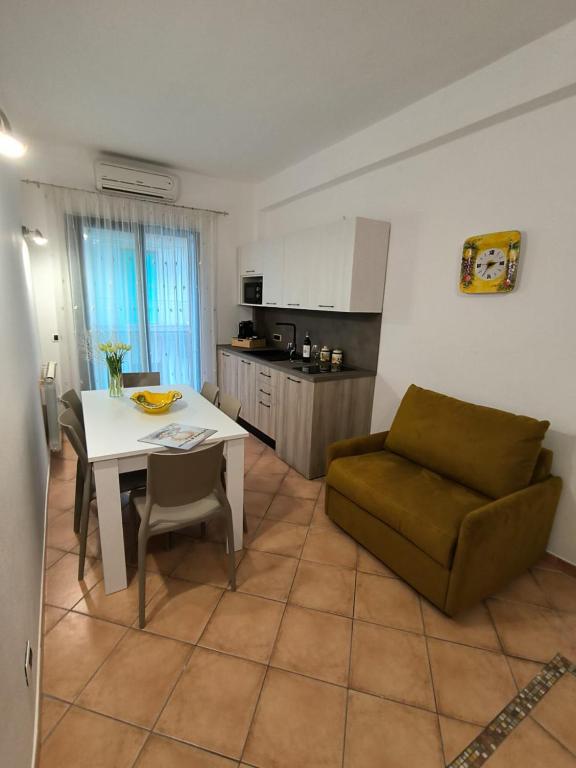 a living room with a table and a couch and a kitchen at Le perle 2 di Naxos in Giardini Naxos