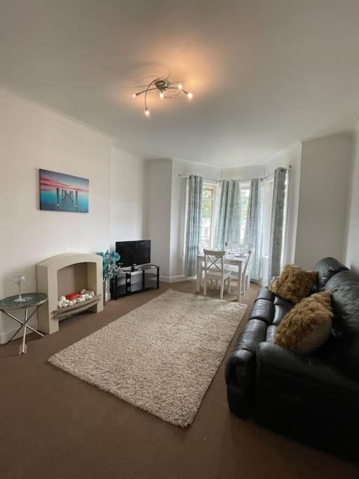 a living room with a leather couch and a table at 2 Bedrooms Holiday home in Edinburgh near City Center in Edinburgh