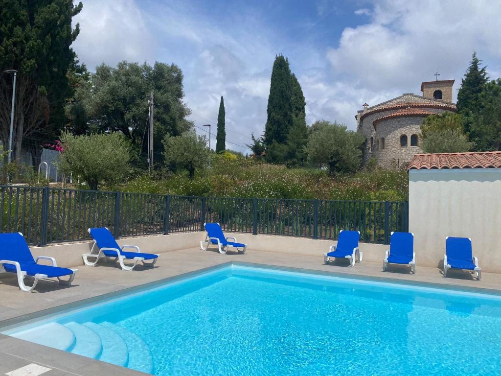 une piscine avec des chaises bleues et une maison dans l'établissement Studio avec Parking Privé, Piscine plage 300m, à Antibes