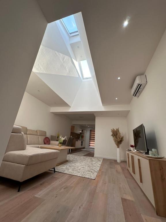 a living room with a couch and a skylight at Luxury Pyramid Apartment Visoko in Visoko