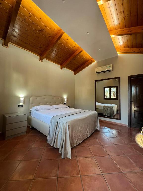 una camera da letto con un letto grande e uno specchio di Hotel 2000 a Giugliano in Campania