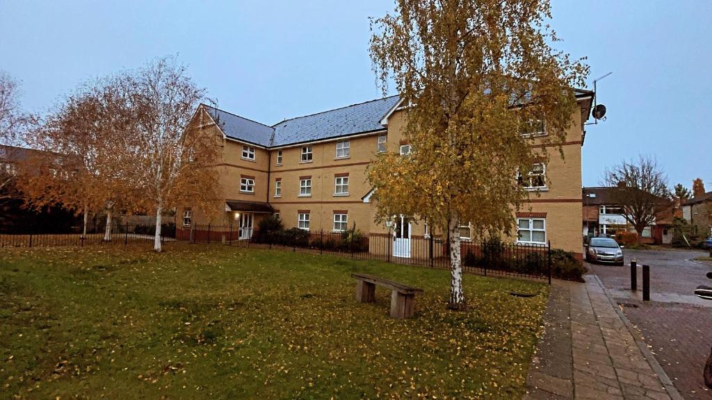 ein Gebäude mit einem Baum und einer Bank davor in der Unterkunft Winstanley Stay in Chesterton