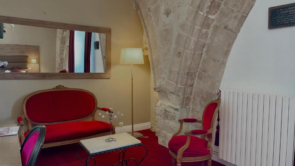a room with two chairs and a table and a mirror at L'Hostellerie du Château de Bricquebec in Bricquebec
