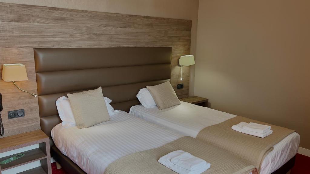 a hotel room with two beds next to each other at L'Hostellerie du Château de Bricquebec in Bricquebec
