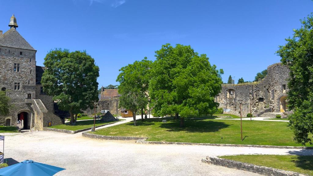 a courtyard of a castle with trees and grass at L'Hostellerie du Château de Bricquebec in Bricquebec
