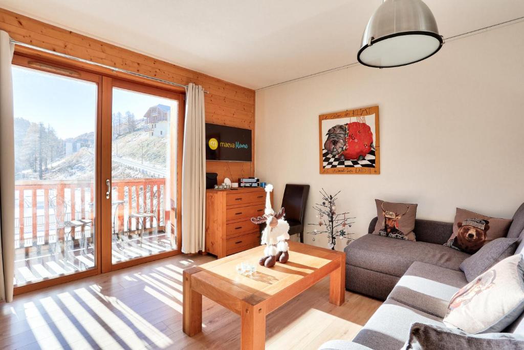 un salon avec un canapé et une table dans l'établissement Résidence Le Chalet des Rennes - maeva Home - Appartement cosy 3 pièces 8 personnes - Exclusive - super Home MAE-6304, à Vars