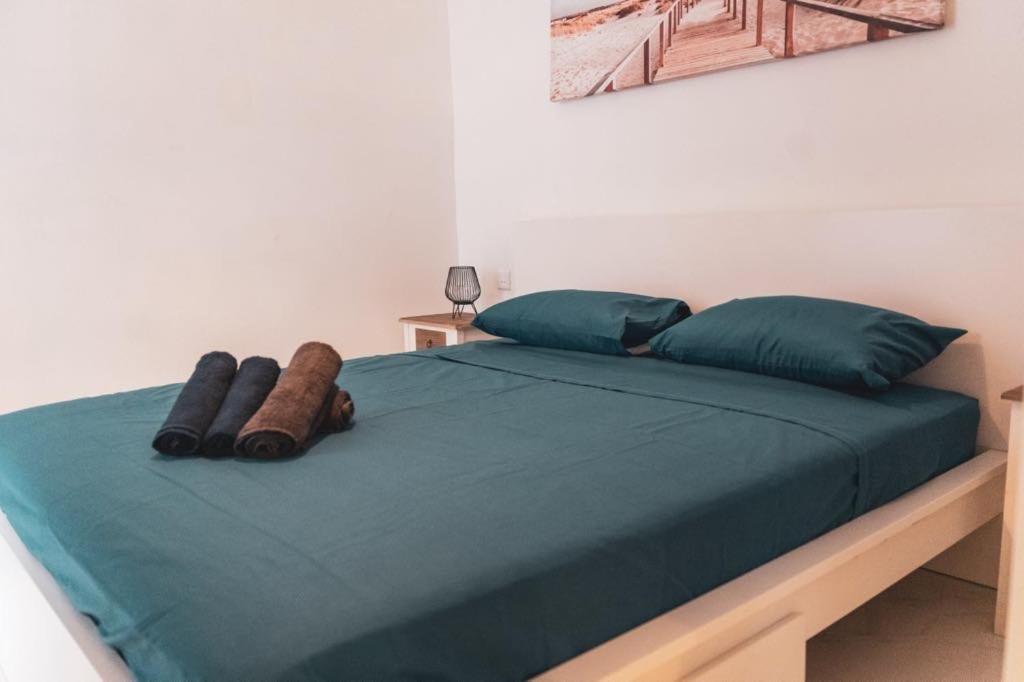 a bed with green sheets and pillows in a bedroom at NORMALT- luxurious stay in Il-Furjana