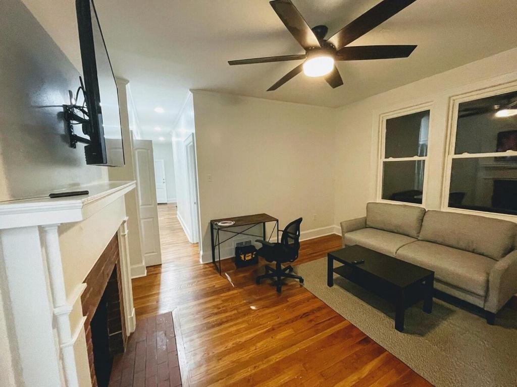 un soggiorno con un divano e un ventilatore a soffitto di Renovated 1 Bedroom In Forest Hills - A a Durham