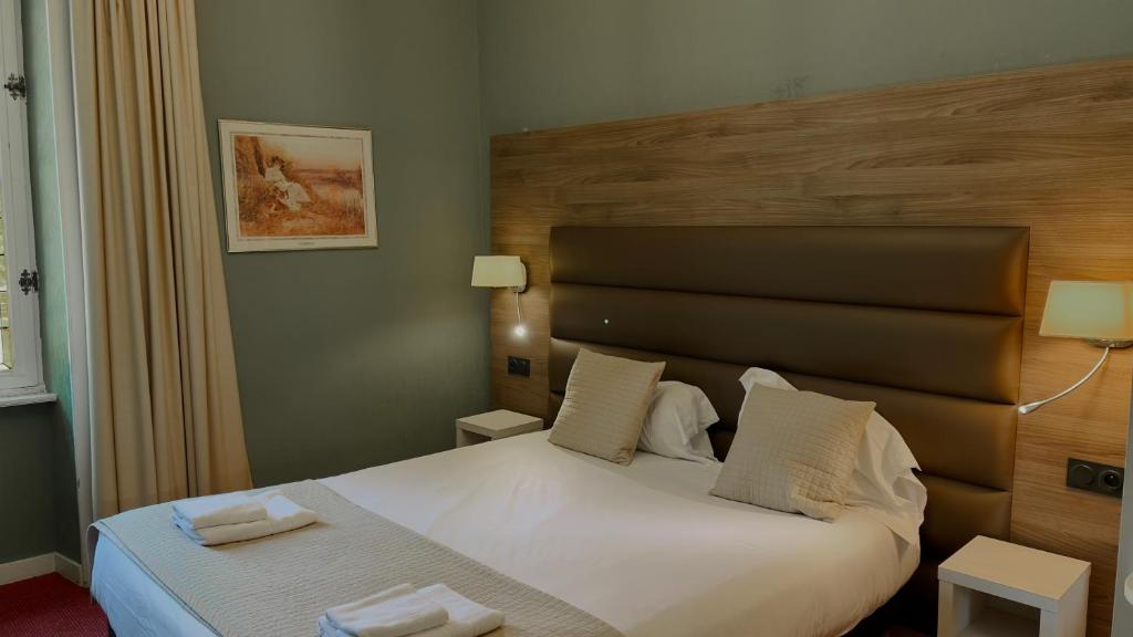 a bedroom with a bed with two towels on it at L'Hostellerie du Château de Bricquebec in Bricquebec