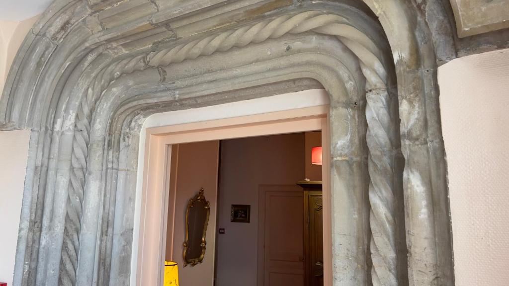 a stone archway over a door in a room at L'Hostellerie du Château de Bricquebec in Bricquebec