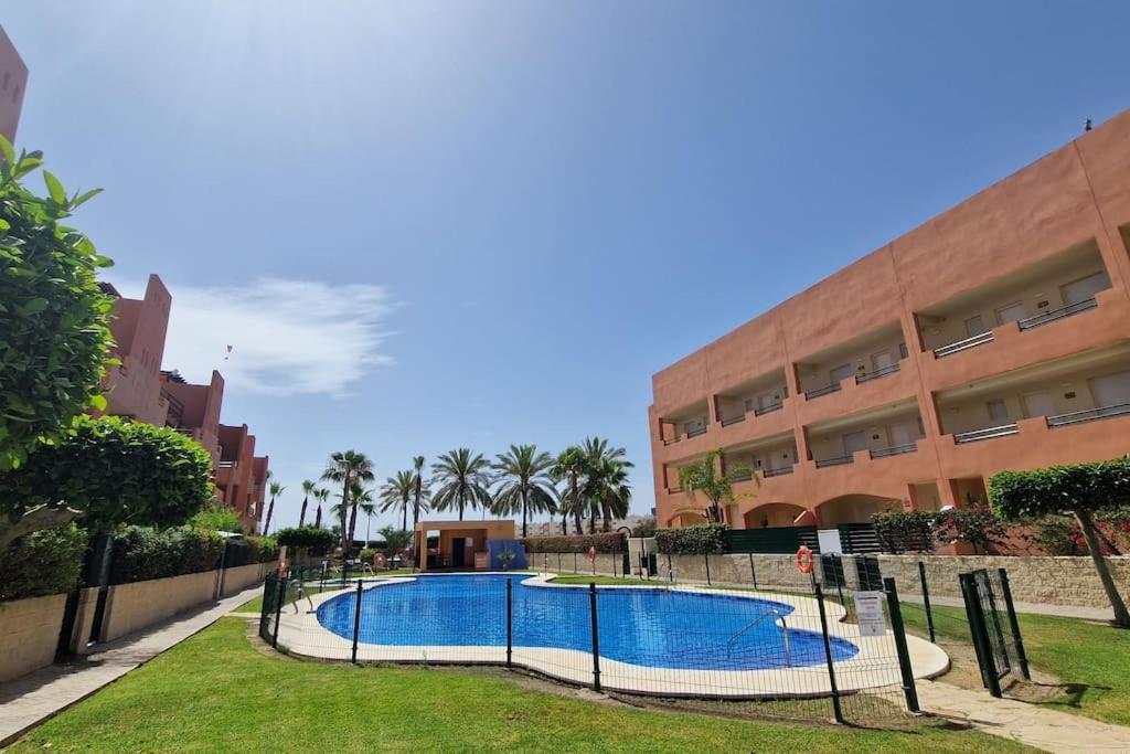 a swimming pool in front of a building at Apartamento junto al mar in Vera