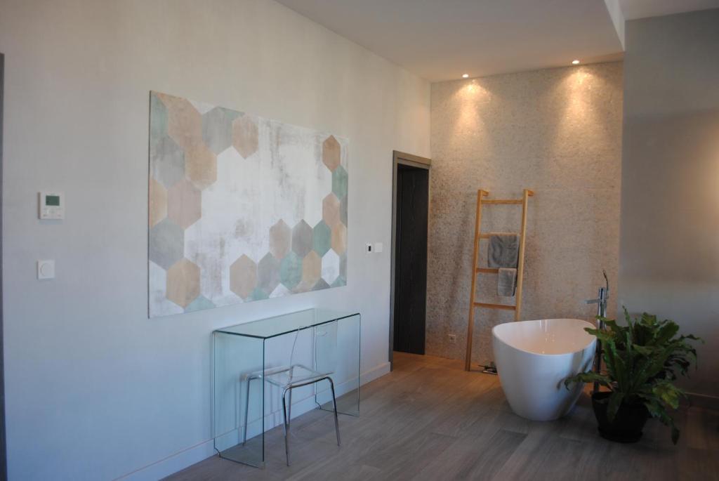 a bathroom with a tub and a plant in a room at Les Suites Massena in Nice