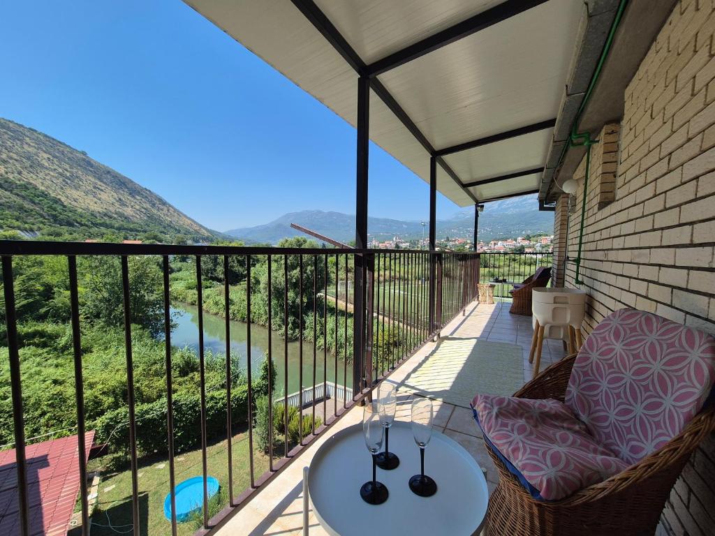 a balcony with a table and chairs and a view at E&E Summer Breeze Apartment in Igalo