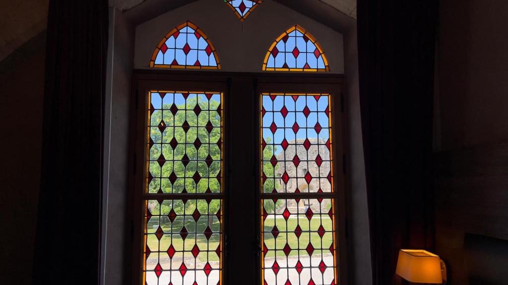 a pair of stained glass windows in a room at L'Hostellerie du Château de Bricquebec in Bricquebec