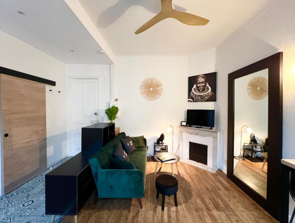 - un salon avec un canapé vert et une cheminée dans l'établissement Studio coeur de ville - proximité plages et Palais des Festivals, à Cannes