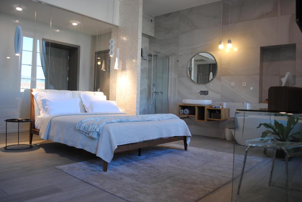 1 dormitorio con 1 cama grande y baño en Les Suites Massena en Niza