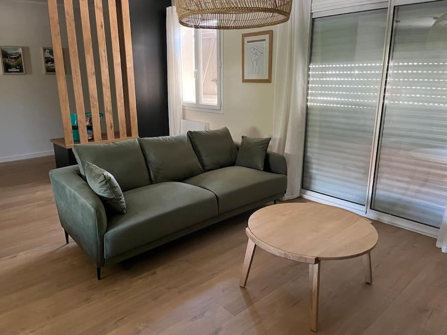 un salon avec un canapé vert et une table dans l'établissement La maison de Marie, à Argelès-Gazost