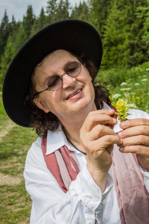 une femme portant un chapeau tenant des fleurs dans ses mains dans l'établissement Marc VEYRAT, à Megève