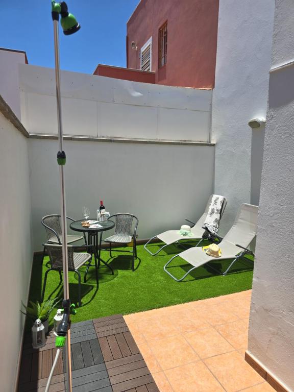 a small patio with a table and chairs on grass at The White Village in Aldea Blanca