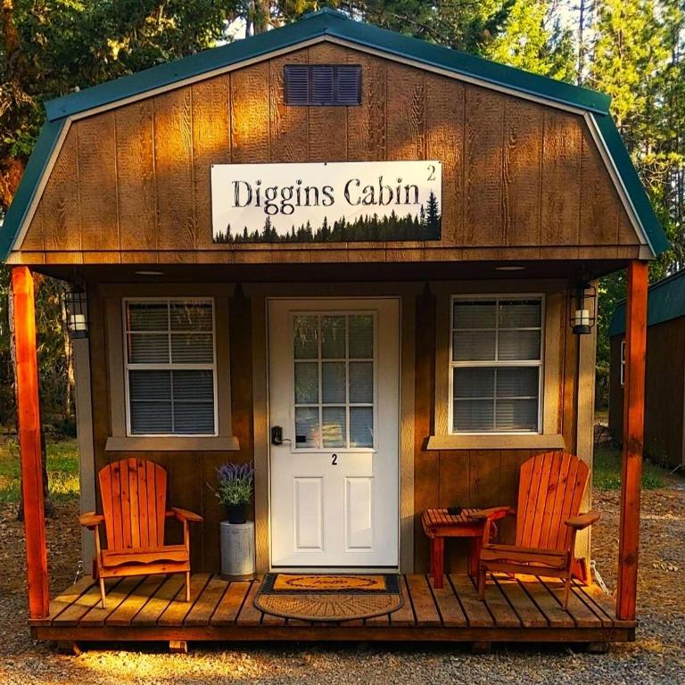 eine Holzhütte mit zwei Stühlen und einer Tür in der Unterkunft Diggins Cabin 2 in O'Brien