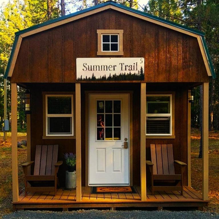 a small shed with two chairs and a white door at Summer Trail Cabin 5 - Sleeps up to 4 in O'Brien