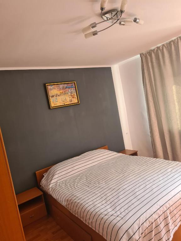 a small bedroom with a bed and a window at Eva Apartments Mall 90mp in Bacău