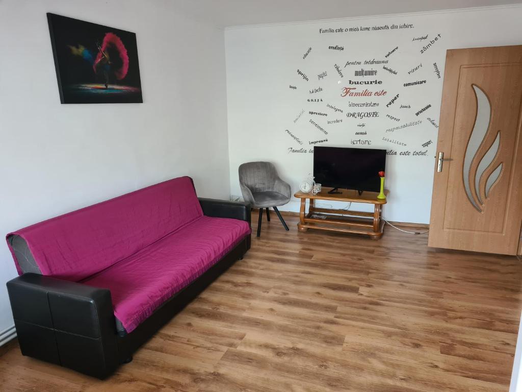 a living room with a purple couch and a tv at Eva Apartments Mall 90mp in Bacău