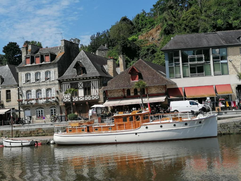 a boat sitting in the water in front of buildings at La Tocade Del Arte - Dinan in Lanvallay