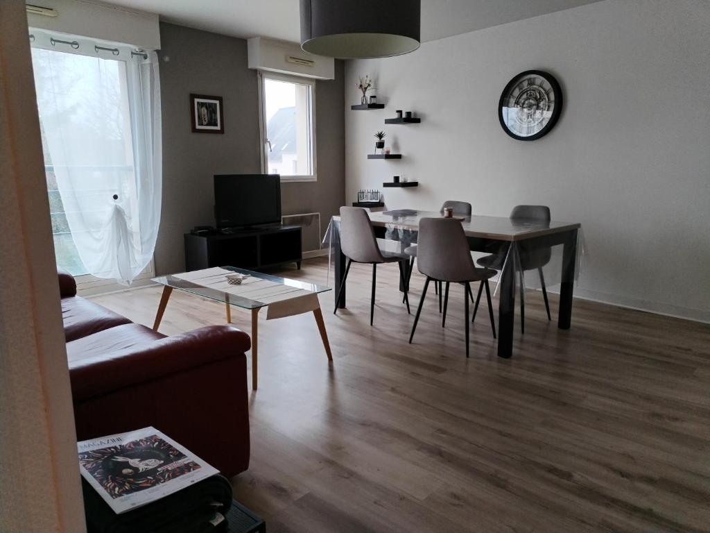 un salon avec un canapé, une table et des chaises dans l'établissement superbe appartement centre ville saint grégoire, à Saint-Grégoire