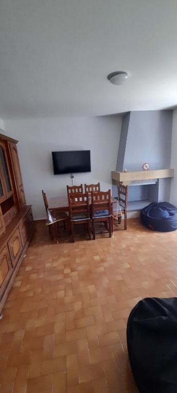 un salon avec une table, des chaises et une télévision dans l'établissement Agréable appartement de 80M2 dans Maison, à Lourdes