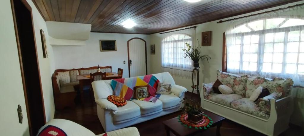 a living room with two chairs and a couch at Casa na Montanha in Campos do Jordão