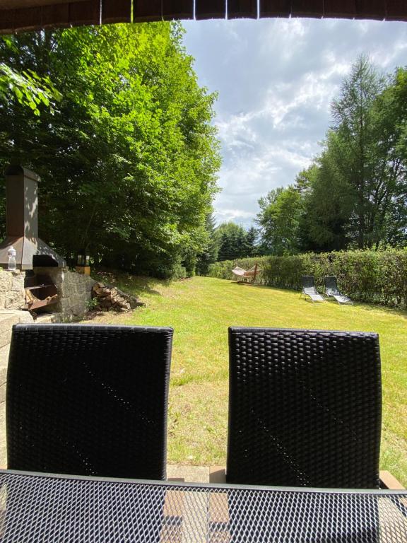 two chairs sitting on a table in a yard at Samostatný apartmán se zahradou in Bedřichov