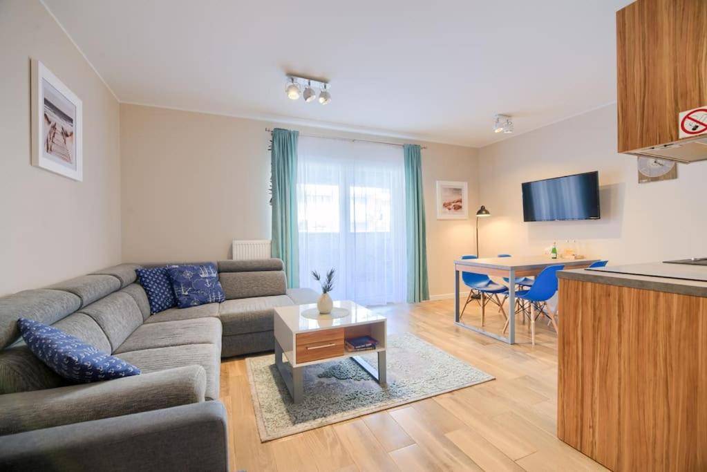a living room with a couch and a table at Studio 51 Baltic Park, 280m do Plaży, Duży balkon in Pogorzelica