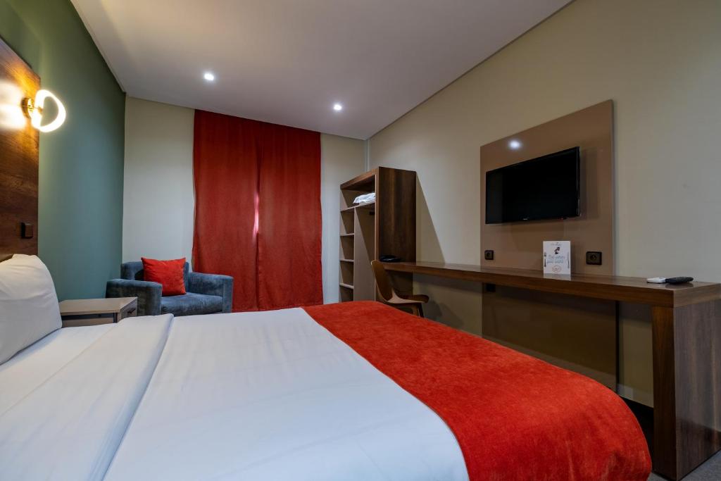 Postel nebo postele na pokoji v ubytování Manzil Hotel
