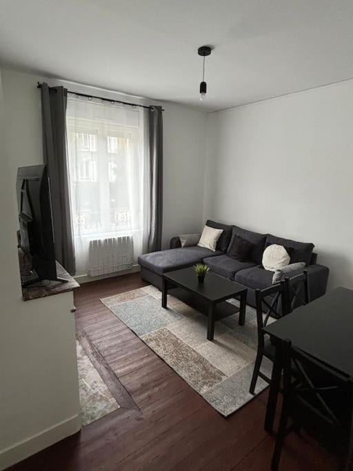 un salon avec un canapé et une table dans l'établissement Appartement style Haussmannien Dreux Centre, à Dreux