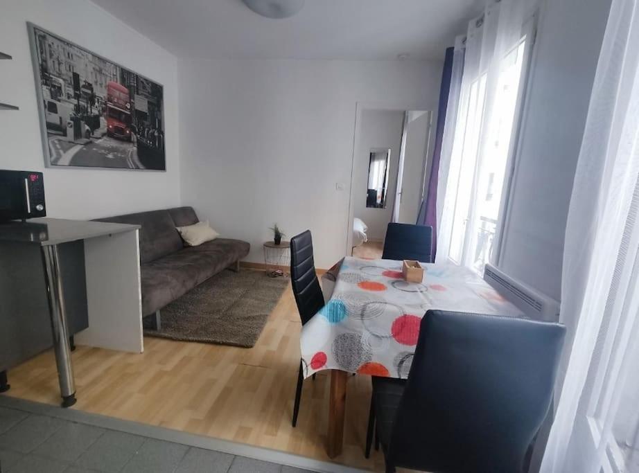 un salon avec une table et un canapé dans l'établissement Facile d'accès et entretenu par femme de ménage, à Paris