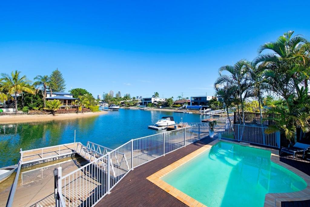 una piscina junto a un río con un barco en Sandy Shores - Large Family Retreat, en Gold Coast