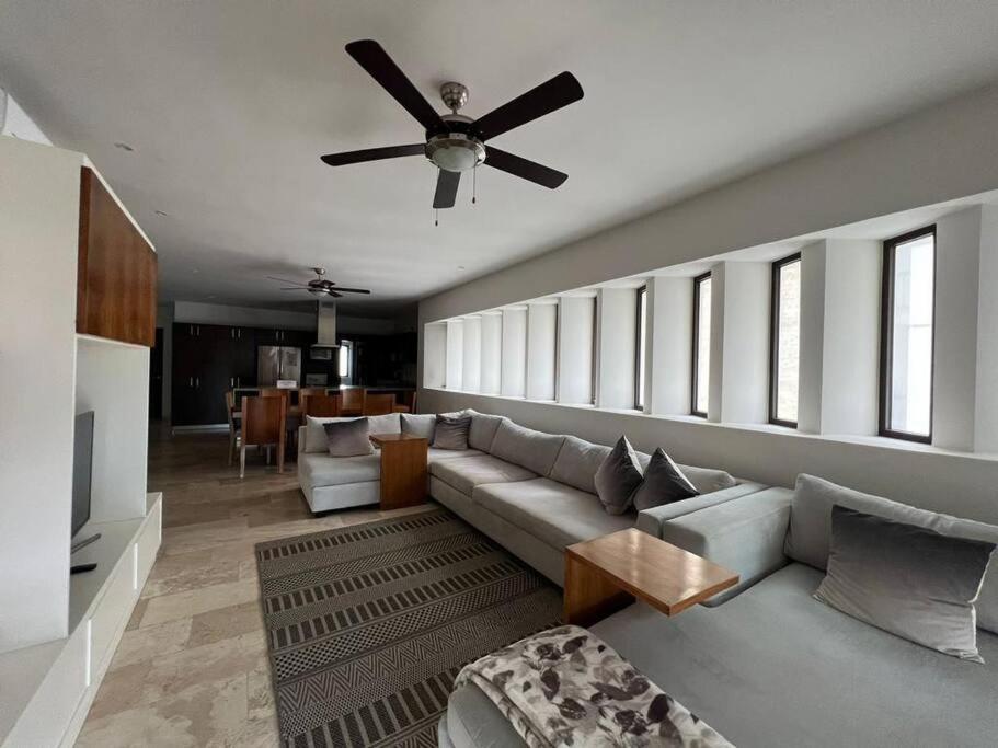 a living room with a couch and a ceiling fan at Exclusivo departamento frente al Mar en Kinuh in Telchac Puerto