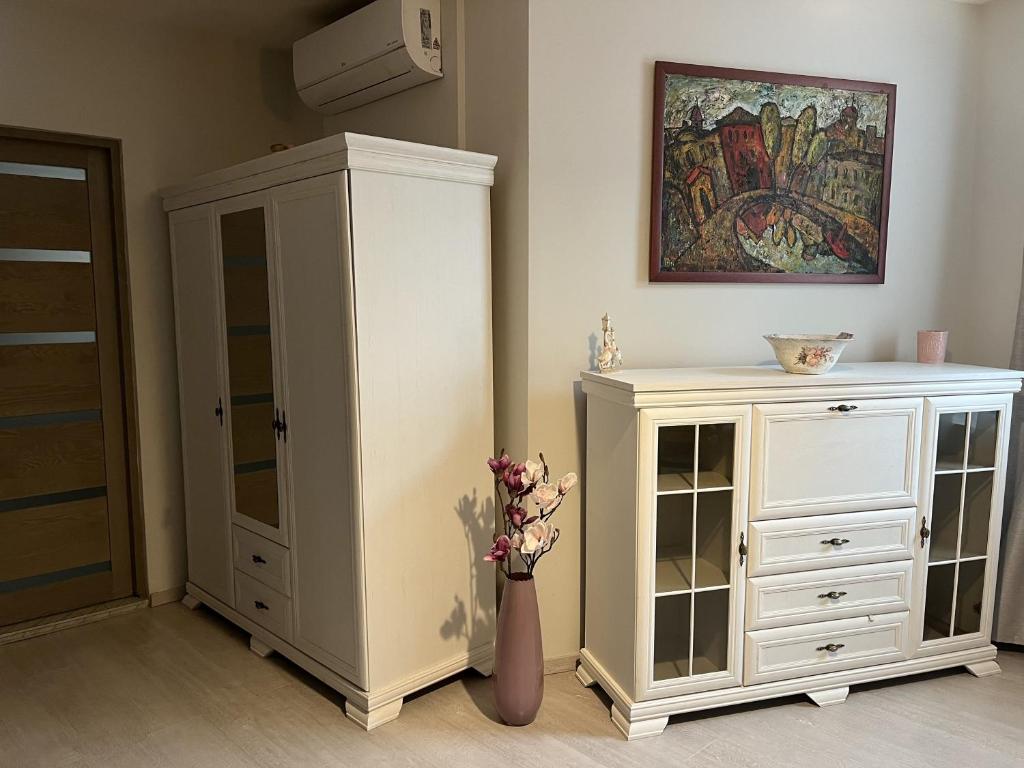 una stanza con un armadietto bianco e un vaso con fiori di Blooming sky a Budapest