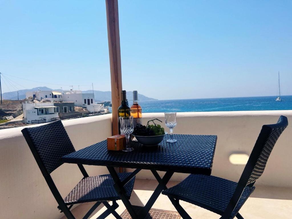 キモロスにあるKimolos Seaviewの海が見えるバルコニーにテーブルと椅子がある