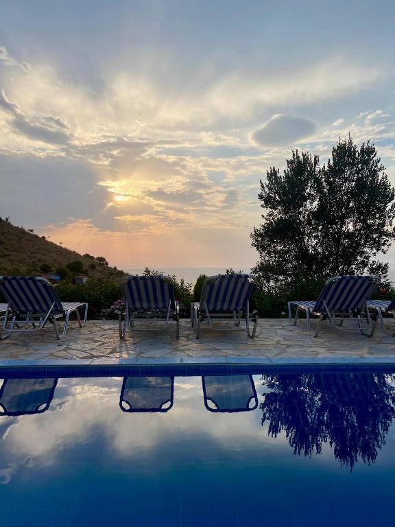 two blue chairs sitting next to a swimming pool at Villa Neimi in Ksamil